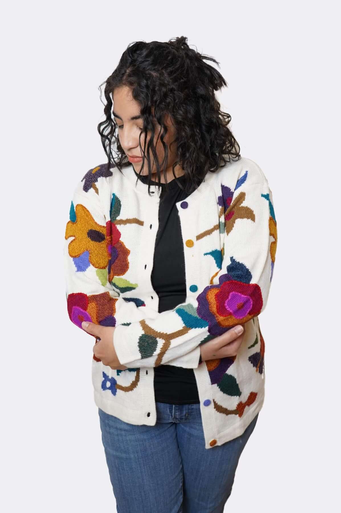 Woman wearing open alpaca floral cardigan - arms crossed